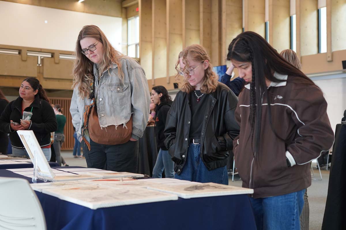 Three students looking at display