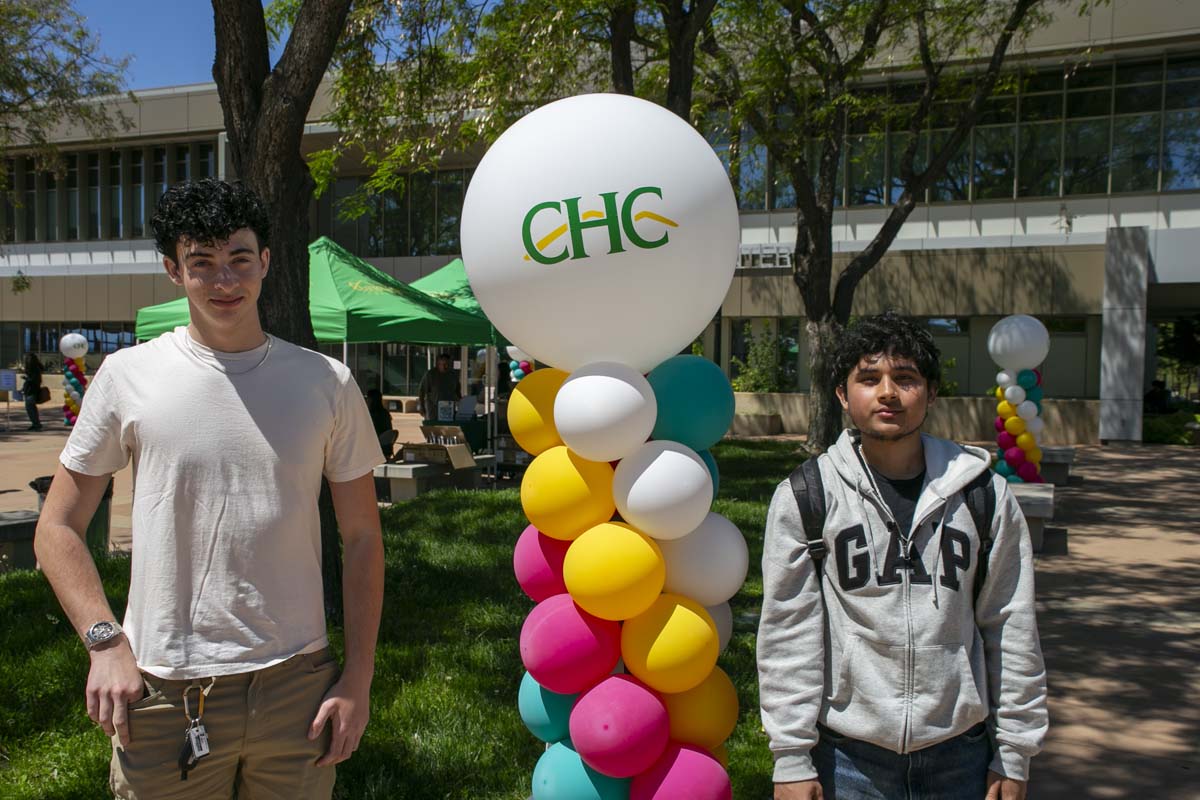 Teo student posing in front of event balloons