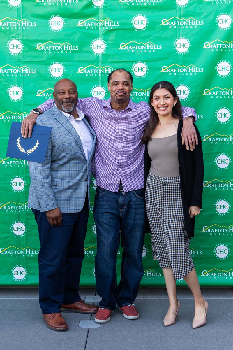 Student and staff posing in front of backdrop