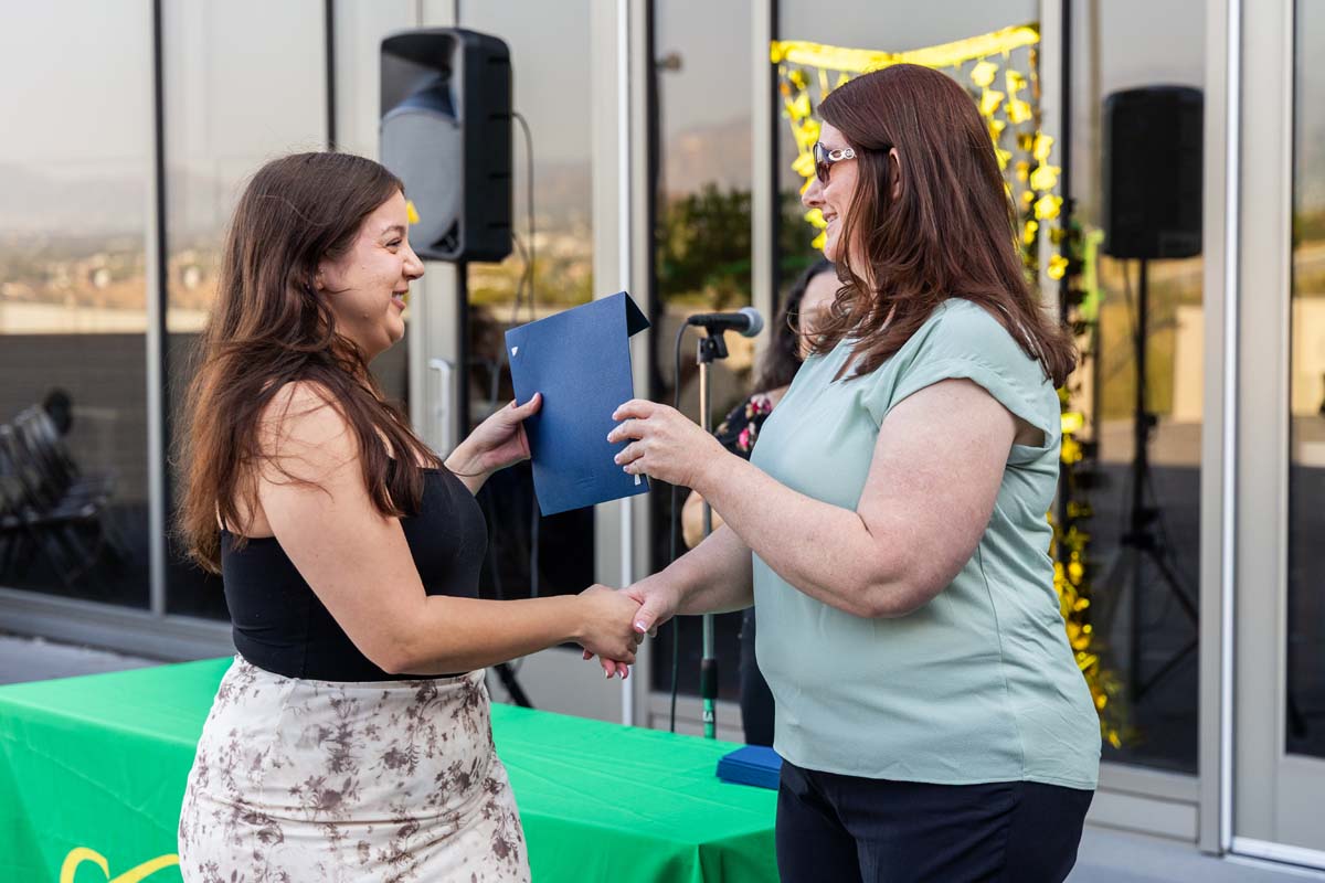 Student grabbing certificate from staff