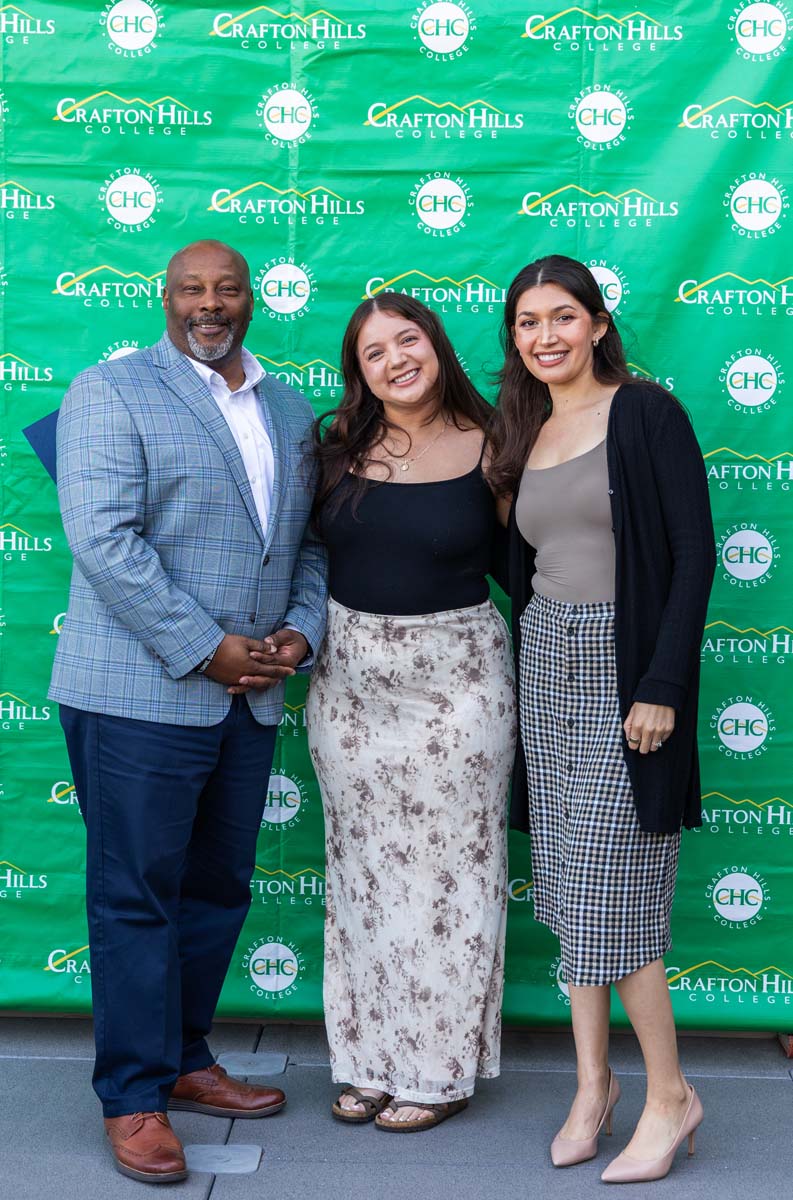 Student and staff posing in front of backdrop