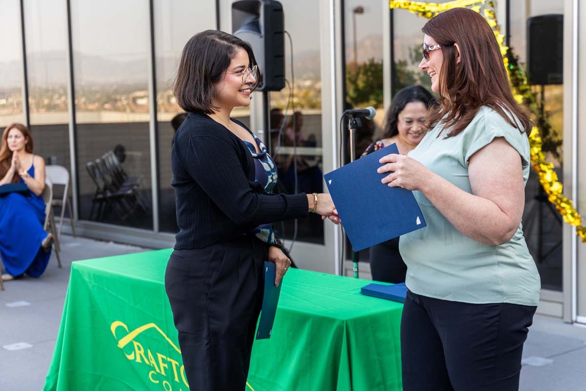 Student grabbing certificate from staff