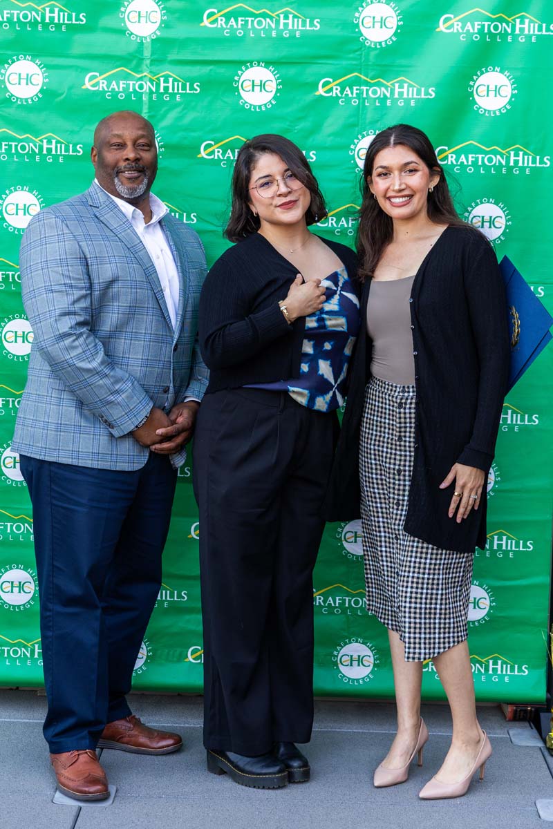 Student and staff posing in front of backdrop