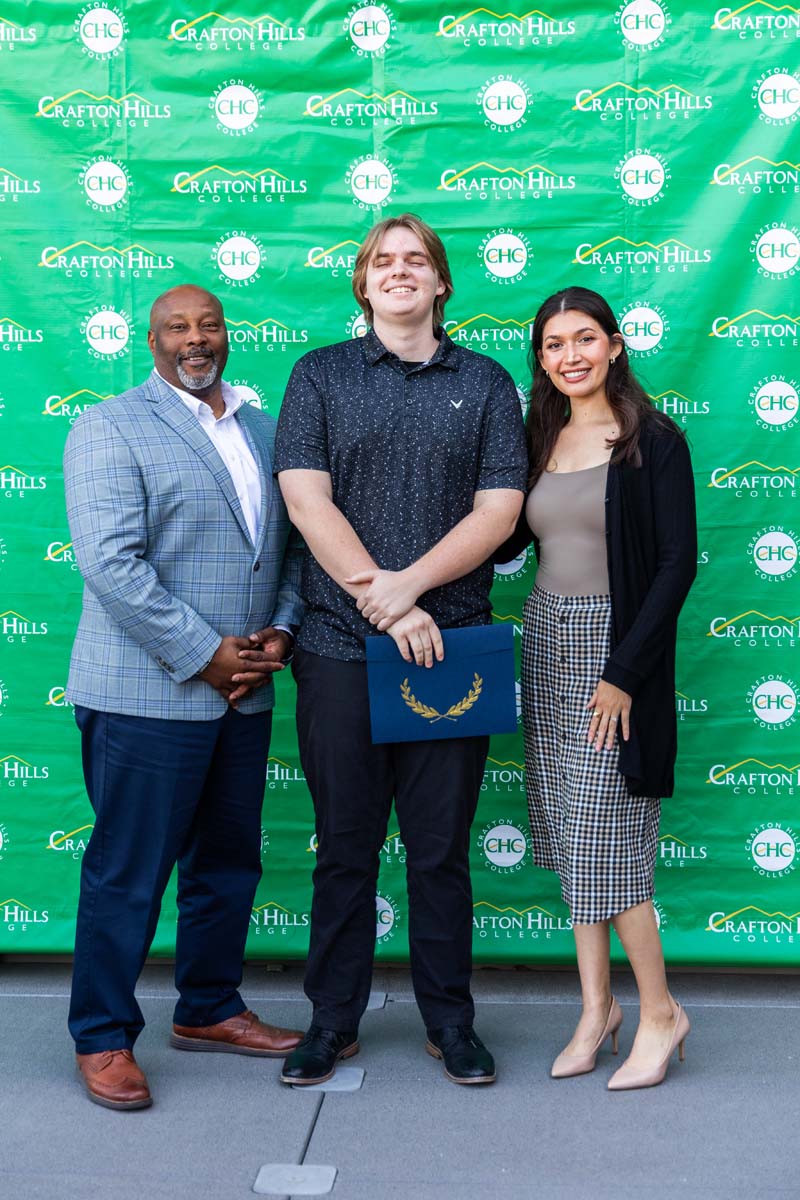 Student and staff posing in front of backdrop