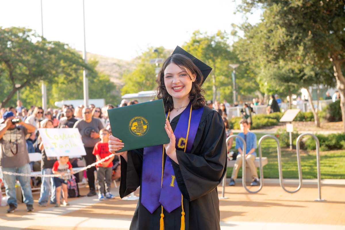 Grad smiling with diploma