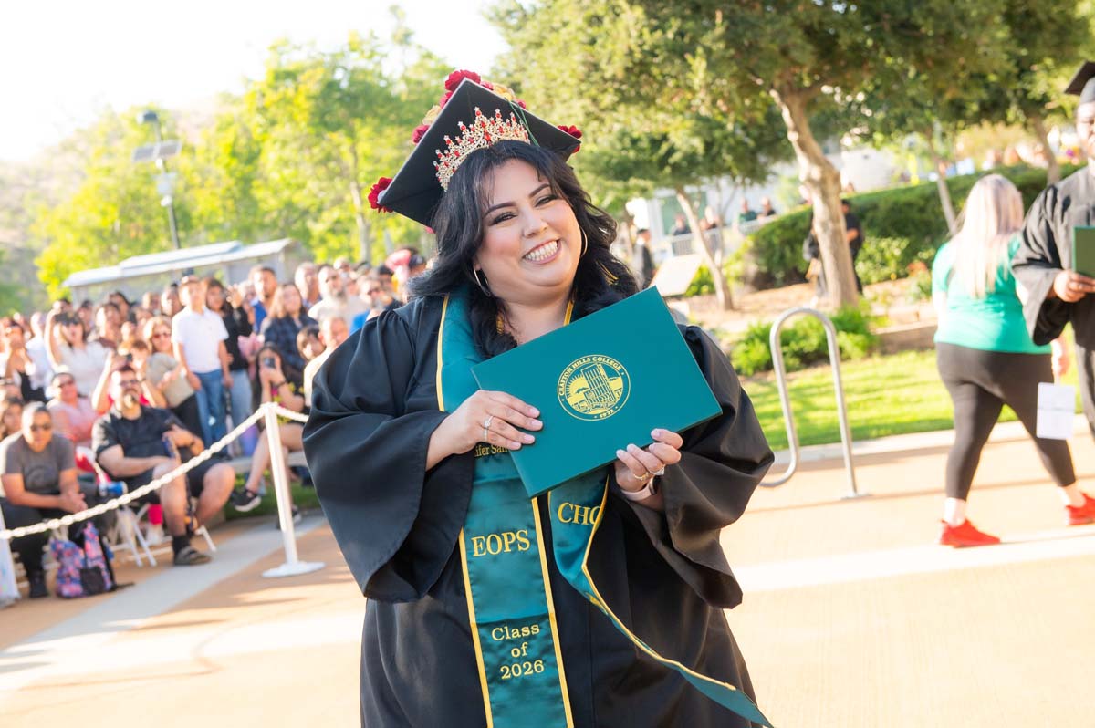 Grad posing with diploma