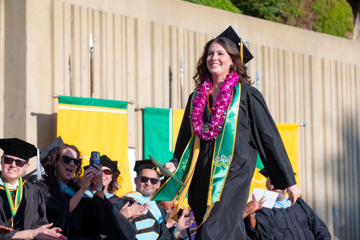 Grad walking across the stage