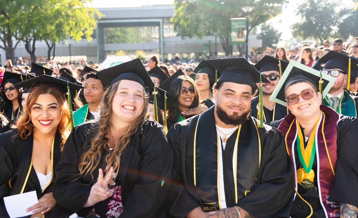 Four Grads sitting and smiling