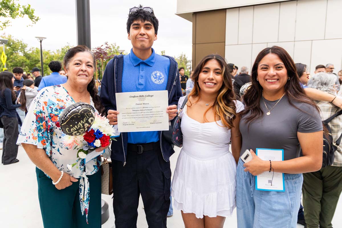 Grad holding certificate posing with family