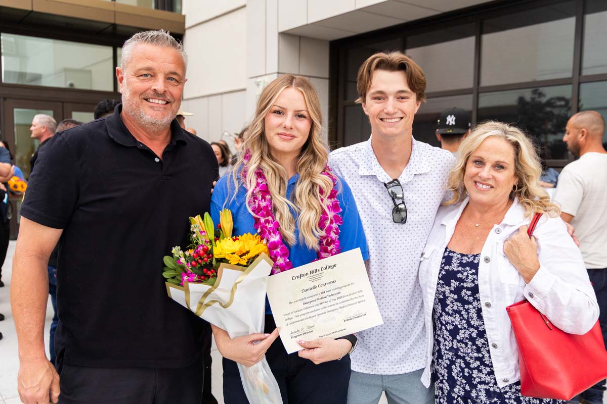 Grad holding certificate posing with family