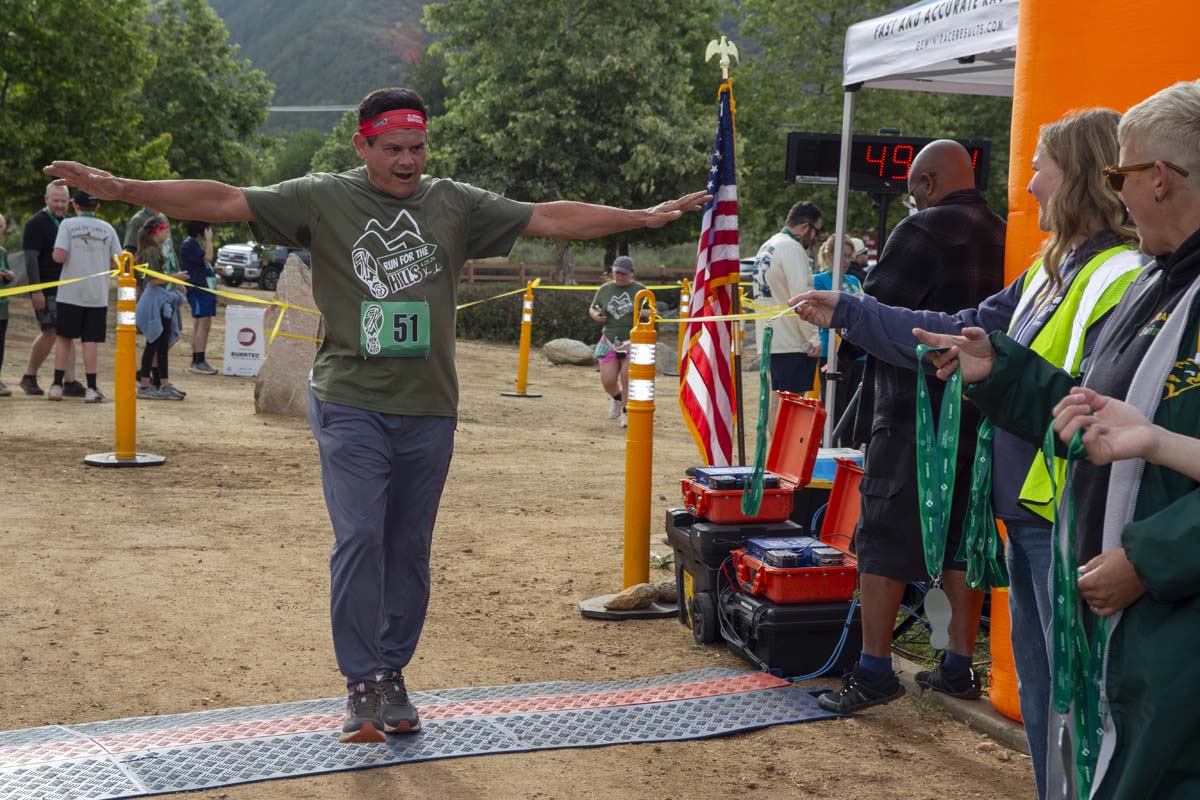 Racer coming across finish line with arms up