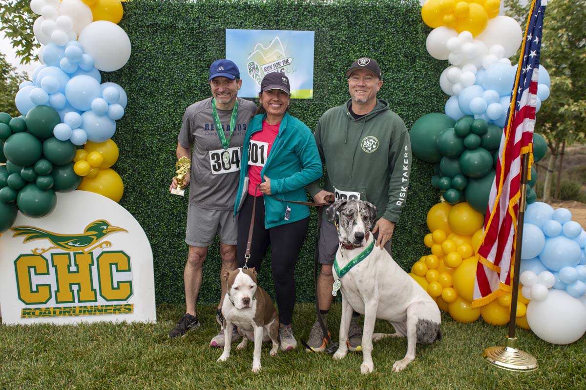 People posing in front of the backdrop with thier dogs