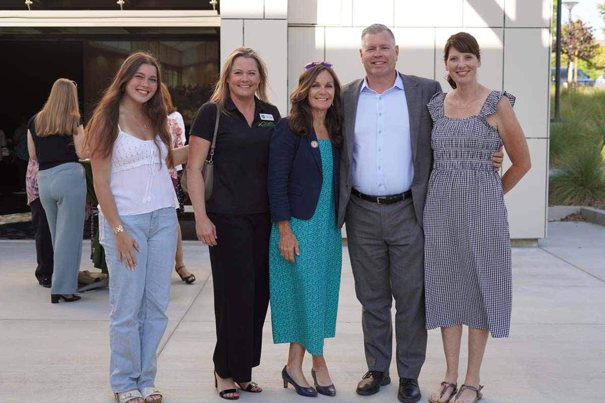 Four people posing with President Horan at event