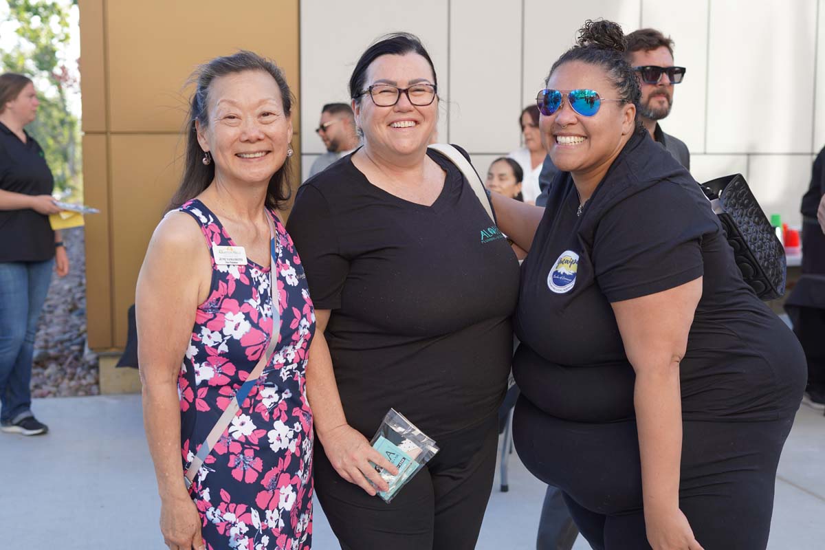 Three people posing at event