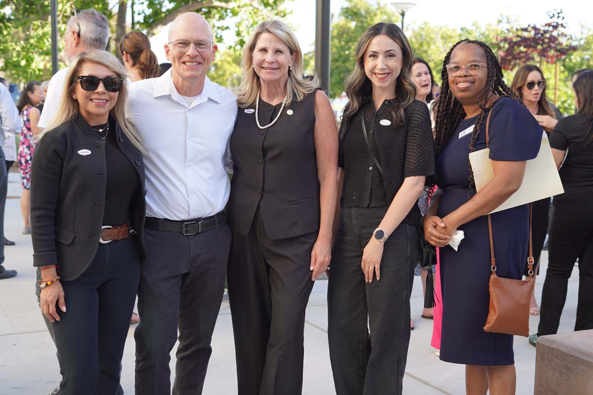 Five people posing at event