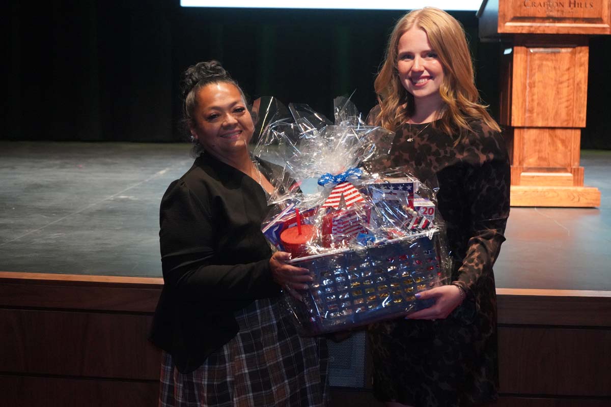 Two people holding gift basket