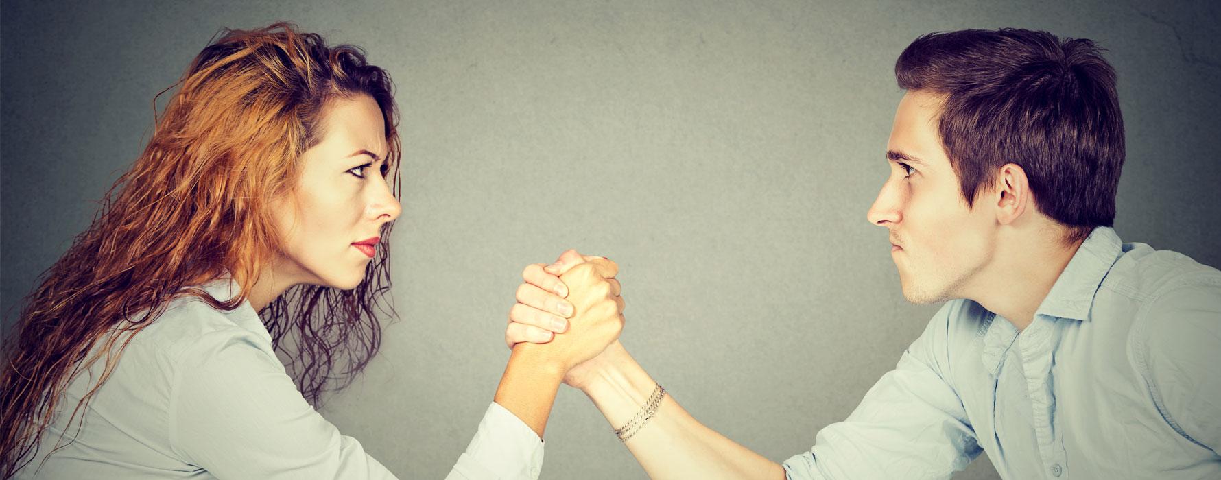 Woman and man arm wrestling