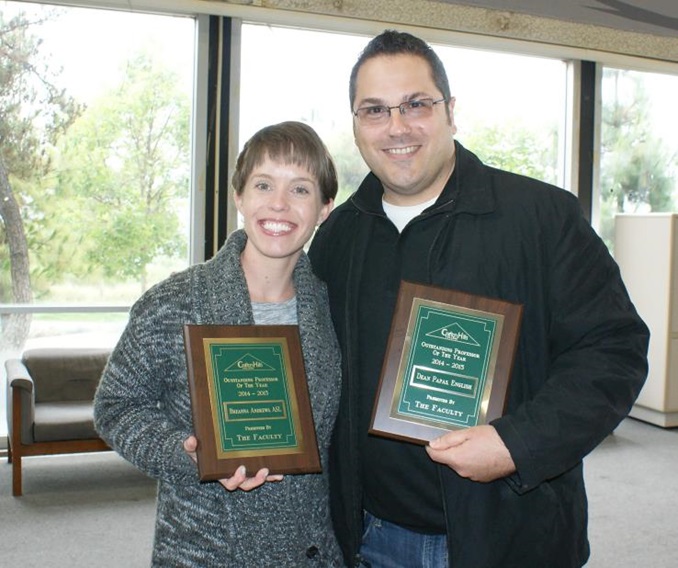 Two professors holding awards