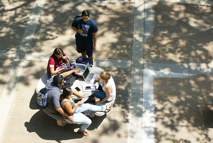 Aerial view of students sitting at a table on campus