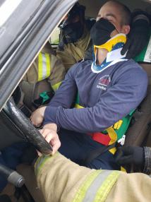 Firefighter in firetruck, wearing medical mask.