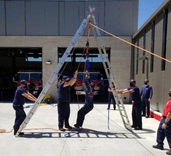 Firefighters training using a ladder.