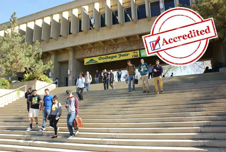 Students walking down campus steps with a checkbox that says "Accredited"