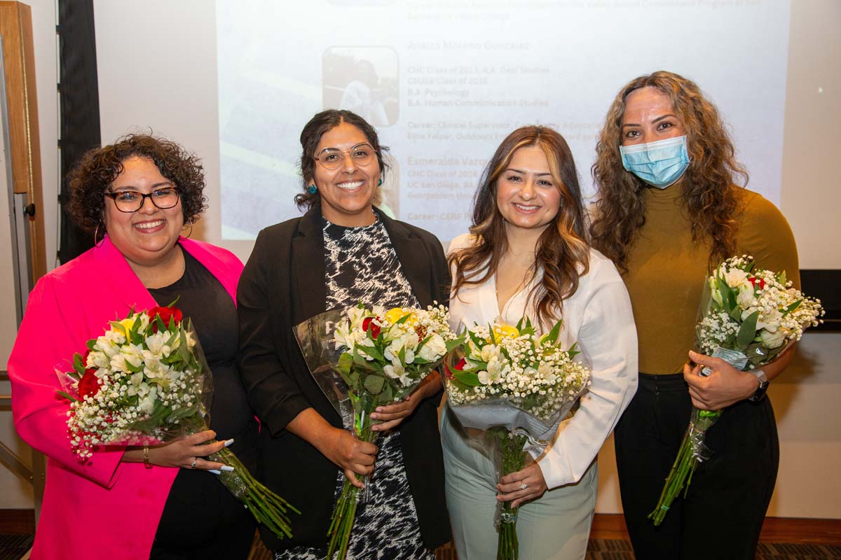 LatinX female alumni holding flowers