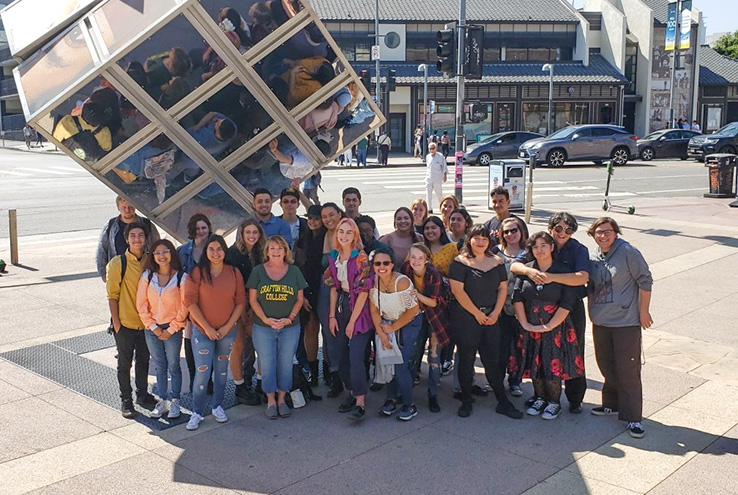 Students next to sculpture