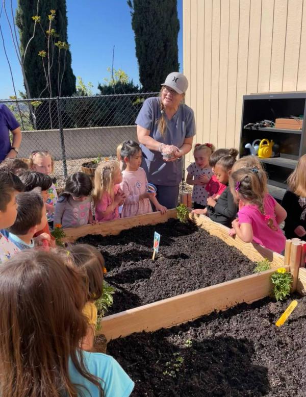 Teacher and students gardening