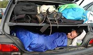 A person asleep in the trunk of a vehicle.
